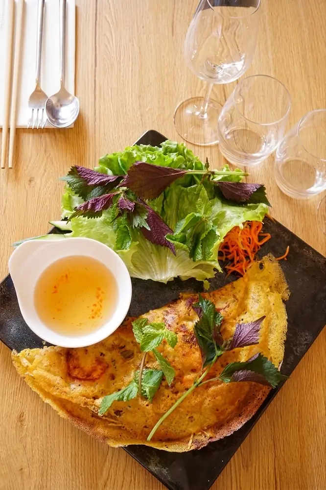 Bánh xèo : crêpe croustillante garnie, herbes fraîches et sauce