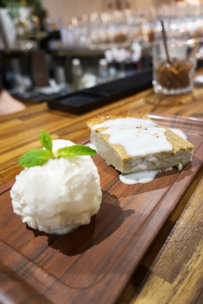 Dessert maison : gâteau nappé de crème de coco et boule glacée à la menthe