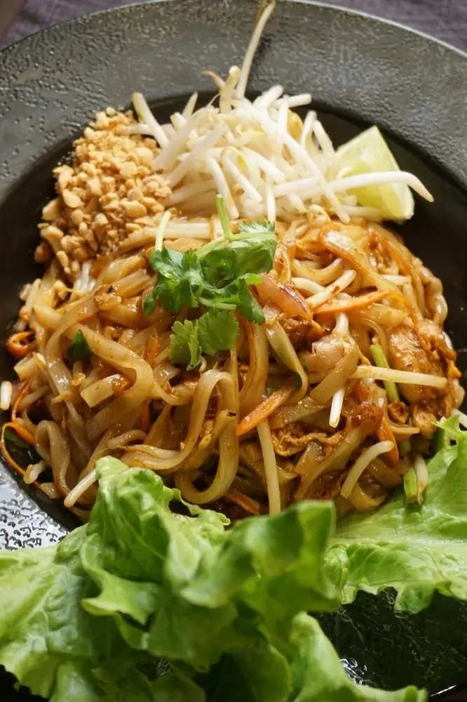 Pad thaï généreux servi avec une salade fraîche