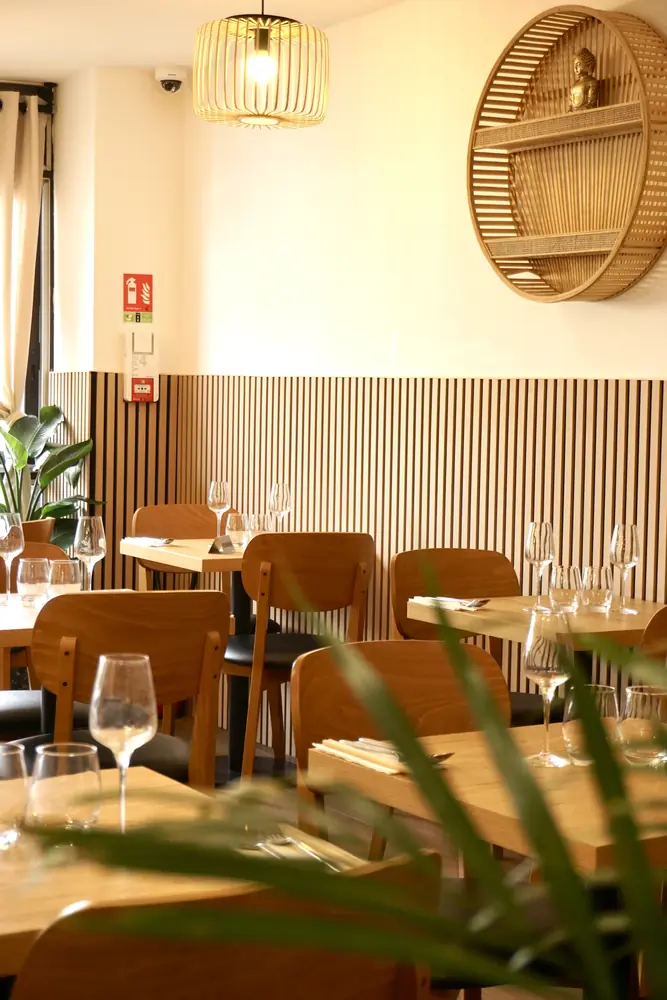 Salle du restaurant Saigon Taverny, tables en bois et boiseries claires