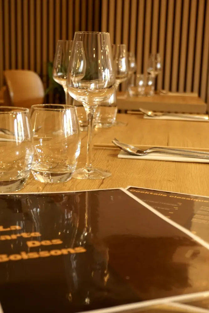 Table dressée avec verres à pied et carte des boissons